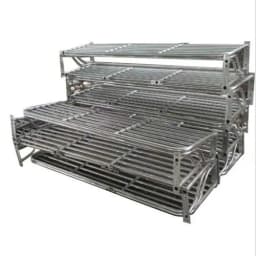 Stainless steel railway luggage racks stacked for installation, featuring durable tubular frame design for passenger coaches.