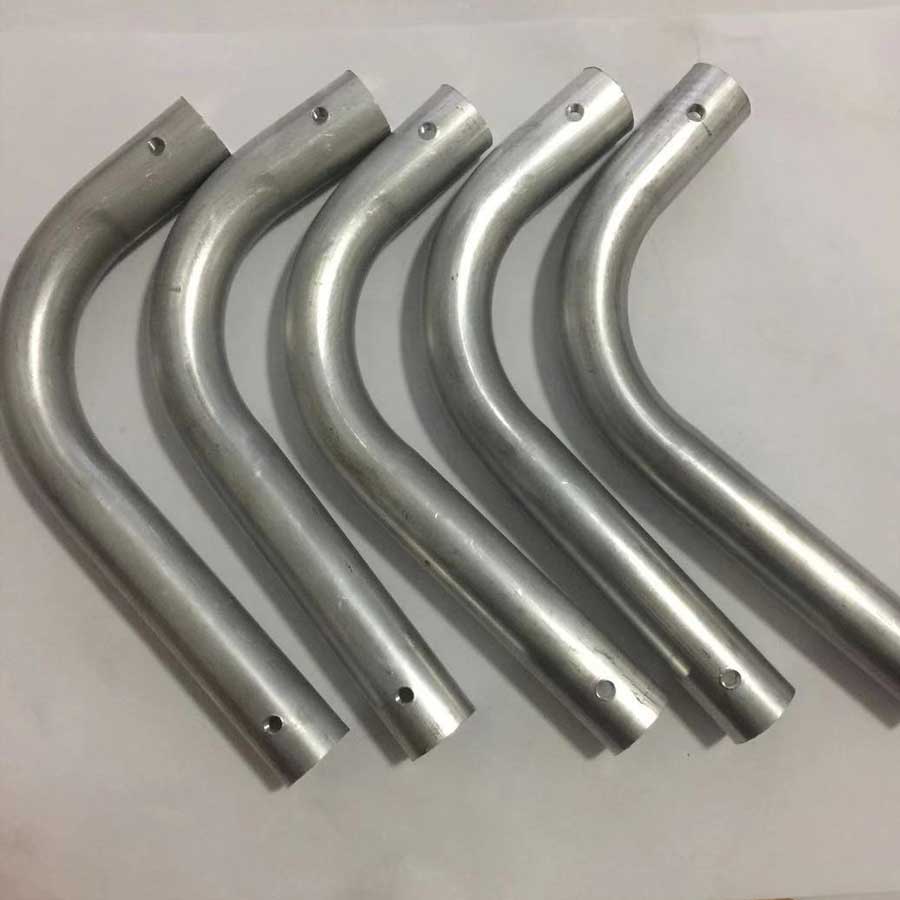 Industrial steel pipes featuring bends with drilled or punched holes.
