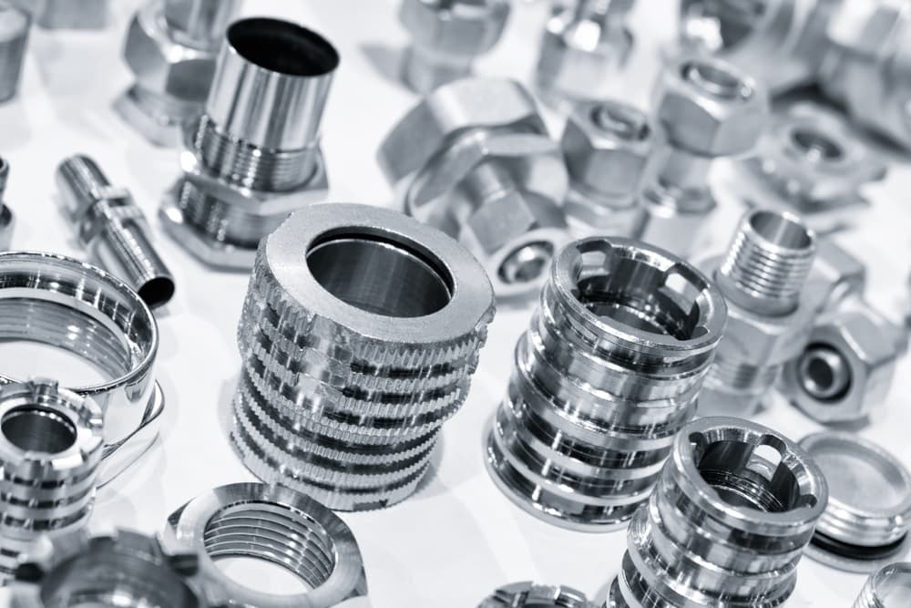 Assorted precision CNC-machined metal parts with threaded and knurled finishes for industrial and mechanical use.