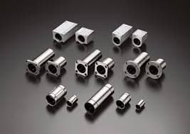 Precision-machined metal components in various shapes and sizes displayed on a dark background.
