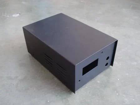 Powder-coated sheet metal box with ventilation slots and front cutouts for switches or display components.